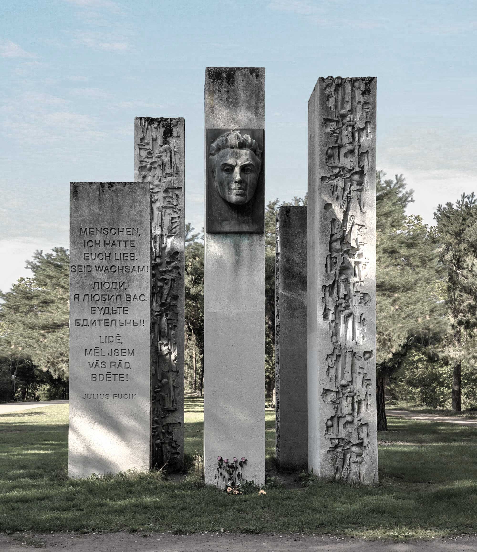 Das Fučík-Denkmal im Pankower Bürgerpark im September 2020. Zu sehen ist die Vorderseite des Denkmals mit dem Profil Fučíks und der Inschrift „Menschen, ich hatte euch lieb. Seid wachsam!“ in deutscher, russischer und tschechischer Sprache.