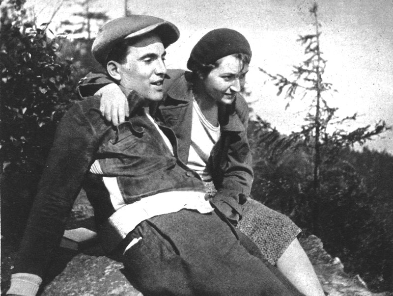 Julius Fučík und Gusta Fučíkova, um 1934- 1936. Fučík sitzt mit seiner Partnerin auf einem Stein. Sie hat einen Arm um ihn gelegt.