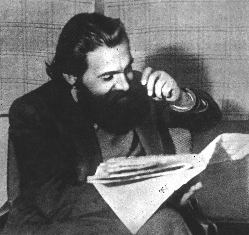 Julius Fučík in der Illegalität, um 1940/41. Ein lachender Fučík mit Vollbart liest eine Zeitung.
