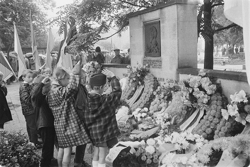 Kranzniederlegung am Dresdner Fučík- Denkmal anlässlich des 25. Jahrestages seiner Hinrichtung im September 1968. Vor dem Fučík-Denkmal in Dresden liegen viele Kränze. Eine Gruppe von Mädchen und Jungen steht vor dem Denkmal und macht den Pioniergruß.