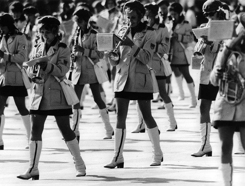 Ein Jugendmusikorchester während der 10. Weltfestspiele im August 1973. Eine Gruppe von jungen Frauen marschiert als Teil des Orchesters, während sie ihre Instrumente spielen.