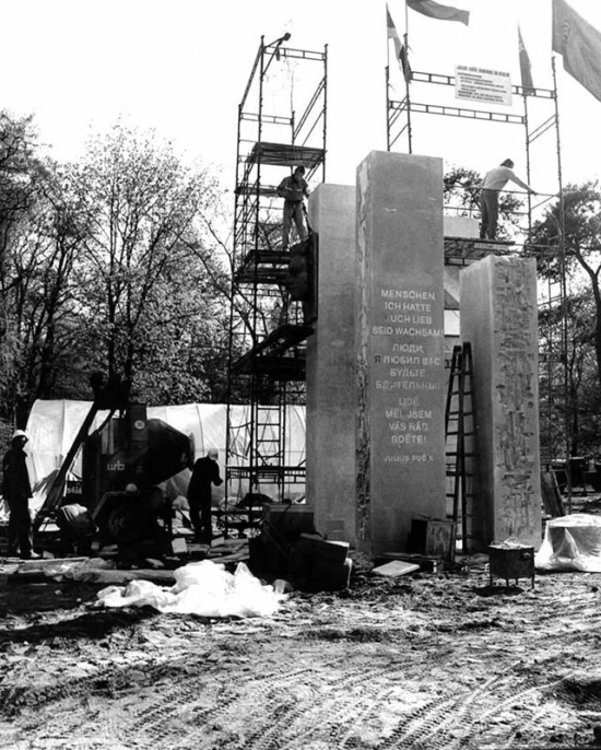Aufbau des des Fučík-Denkmals im Bürgerpark Pankow, um 1973/74. Bauarbeiter arbeiten auf dem Baugerüst, das um die Stelen des Denkmals errichtet wurde.